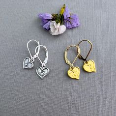 ✦These cute, dainty earrings make a great gift for a daughter, best friend or girlfriend. Tiny heart charms dangle from sturdy leverback or French hook ear wires. ✦ Heart charms: sterling silver or 14k gold vermeil (gold plated over sterling silver), 15mm in diameter, with a polished surface, measuring 9mm x 9mm, (3/8" x 3/8"). ✦Ear wires: sterling silver or 14k gold-filled, select from either French hook or leverback style.  ✦Length of earring is 7/8". ✦Your jewelry will be packaged in a beautiful and reusable organza bag. All items will be placed in the same organza bag. If you need a separate bag for each item, please leave a comment at check out. ✦Giving your purchase as a gift? If you would prefer that prices not be printed on your invoice, please check "this item is a gift".  ✦To rec Dainty Heart Charm Earrings For Everyday, Dainty Hypoallergenic Huggie Heart Earrings, Dainty Heart Drop Earrings For Gift, Dainty Dangle Heart Earrings For Everyday, Gold Hypoallergenic Heart Earrings In Sterling Silver, Gold Sterling Silver Hypoallergenic Heart Earrings, Hypoallergenic Heart Drop Earrings For Mother's Day, Dainty Yellow Gold Sterling Silver Heart Earrings, Nickel Free Dangle Heart Earrings For Anniversary