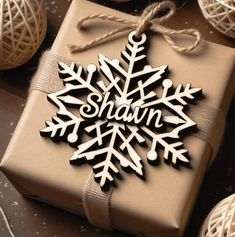 a present wrapped in brown paper with a snowflake ornament