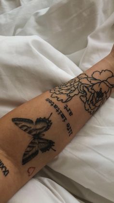 a person laying in bed with a tattoo on their arm