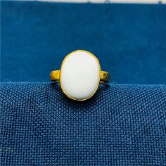 "White Coral 5.25 carat Gold Plated Ring Handcrafted Indian jewelry. Ring is in Gold Plated and finished with Rhodium EXCELLENT GIFT: for birthday, anniversary, holidays, stocking stuffers, graduation, Christmas, Valentine's Day, Mother's Day, Thank You or simply \"Thinking of You ALL RING SIZES AVAILABLE: We have our own manufacturing unit. We can deliver all custom ring sizes on request. CONTACT US: If you have any question, please post into \"Customer Questions & Answers\" below the \"Product specifications\".  Product colour may slightly vary due to photographic lighting sources or your monitor settings. Top Quality Craftsmanship Exceptional Styling ENTER OUR SHOP HERE for more fabulous jewelry :  https://www.etsy.com/in-en/shop/JwellsFarms?ref=seller-platform-mcnav" White Oval Cabochon Gemstone Ring, White Hallmarked Opal Ring Fine Jewelry, Gift White Opal Gemstone Ring, Classic White Round Opal Ring, White Moonstone Ring With Oval Cabochon, White Cabochon Moonstone Ring In Fine Jewelry Style, White Cabochon Moonstone Ring Fine Jewelry, White Oval Cabochon Moonstone Ring, Fine Jewelry White Cabochon Moonstone Ring