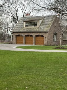 a large brick house with two garages on each side