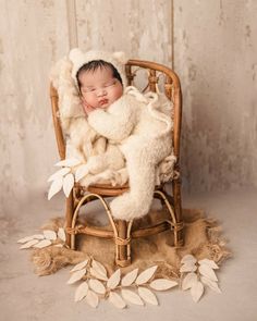 a baby is sleeping in a chair with a teddy bear on it's back