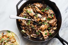 a skillet filled with chicken, mushrooms and pasta next to a bowl of noodles