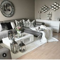 a living room filled with furniture and lots of pillows on top of a white rug