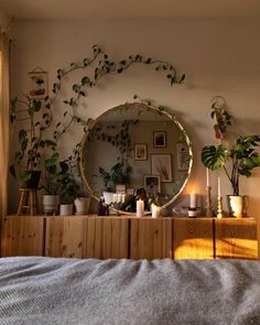 a bedroom with plants on the wall and a round mirror