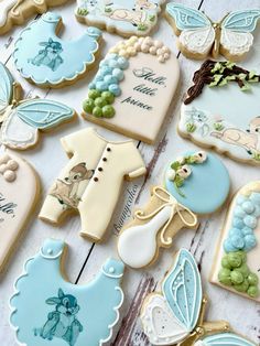 some decorated cookies are laying on a white wooden table with blue and green decorations around them