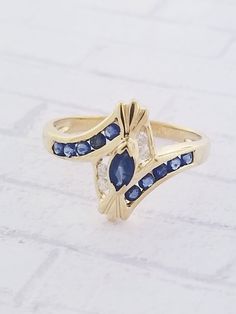 Vintage Sapphire & Diamond ring. Details: Size: US 6 1/2 ( can be sized ) Weight: 2.1 grams Primary stone: Genuine Sapphire Shape: Marquise & Round Secondary Stone: Diamond ( Appx. 0.06 tcw. ) Shape: Round Metal: 10k Yellow Gold Condition: Previously worn/great condition Inside of band is stamped and tested for '10k' gold. All pieces are polished and refinished in our shop. SIZING: Currently this ring is a size 6 1/2 but could be sized up or down for an additional small fee if desired by Marquise Cut Multi-stone Diamond Ring For Anniversary, Fine Jewelry Marquise Multi-stone Ring, Marquise Cut Multi-stone Yellow Gold Diamond Ring, Fine Jewelry Sapphire Ring With Accent Stones For Anniversary, Fine Jewelry Marquise Cluster Ring With Accent Stones, Yellow Gold Multi-stone Jewelry For Anniversary, Classic Multi-stone Marquise Rings, Multi-stone Sapphire Rings, Sapphire Multi-stone Round Cut Rings