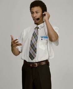 a young man wearing a white shirt and tie talking on a cell phone