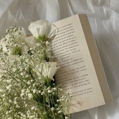 an open book with white flowers and baby's breath