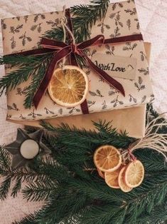 two wrapped presents sitting next to each other on top of a table with orange slices