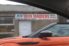 an orange car parked in front of a building