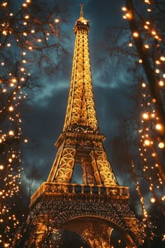 the eiffel tower lit up at night with lights on it's sides