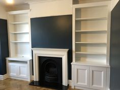 an empty living room with bookshelves, fireplace and built - in shelving