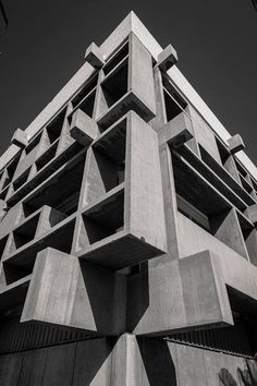 a tall concrete building with balconies on top