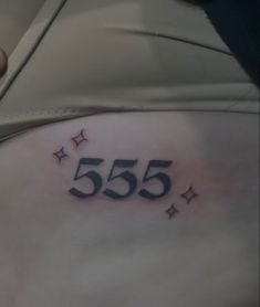 a woman's stomach with the number 555 written on it and stars around her belly