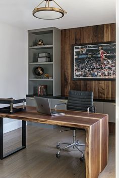 a laptop computer sitting on top of a wooden desk next to a book shelf filled with books