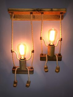 two light bulbs are attached to ropes on the wall