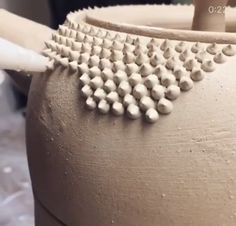 a close up of a tea pot with white beads on it's lid and handle