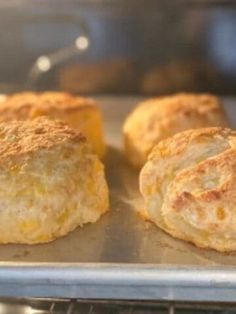 three biscuits sitting on top of a metal pan