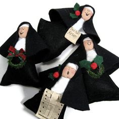 four black felt christmas ornaments with white and red decorations on them