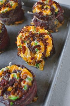 mini pizzas with cheese and other toppings on a baking sheet