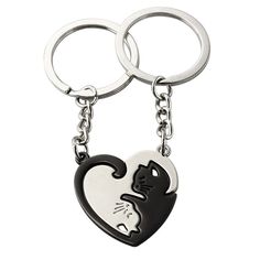 two black and white cats in a heart shaped keychain on a white background