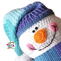 a crocheted snowman wearing a blue and purple hat with a knitted scarf