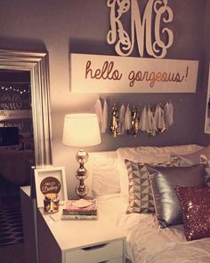 a white bed topped with pillows next to a night stand and lamp on top of a dresser