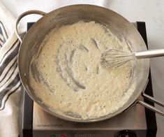 a frying pan filled with batter sitting on top of a stove next to a towel