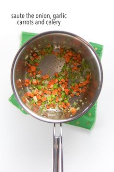 a pan filled with carrots and celery on top of a green cloth