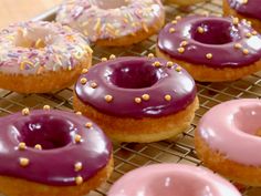 there are many donuts with purple frosting and sprinkles on them