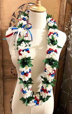 a white mannequin with red, white and blue flowers on it's neck