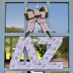 a pink and green door hanger with the letter za on it's side