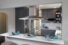 a modern kitchen with stainless steel appliances and gray cabinets