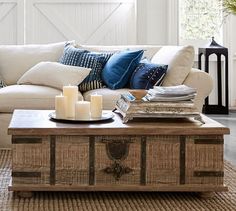 a living room with a couch, coffee table and two candles on the end tables