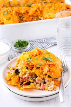 a white plate topped with mexican casserole on top of a table