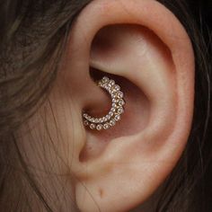 a woman's ear is shown with an earring in the shape of a crescent