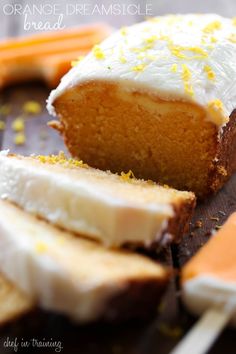 an orange cake with white frosting and sliced carrots