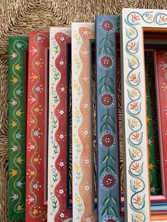 an assortment of painted wooden frames sitting on top of a wicker flooring mat