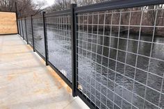 a black fence next to a body of water