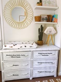 a white dresser with drawers and a mirror above it