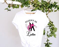 "Here is a fantastic dancer's t-shirt that would be perfect for the latin dancer in your life.  It reads \"Fluent in Latin\" and has an image of latin dancers mid pose in silhouette with the features picked out in fluorescent pink although I can make this in different colours so can make this a beautiful dance gift which can be bespoke to your requirements. Graphics are adhered to each shirt using a heat transfer process for durability and long-lasting wear.  To specify your item size, choose fr Salsa Dancer, Dance T Shirt, Beautiful Dance, Dance Gifts, Latin Dance, Heat Transfer, Bespoke, Inside Out, Long Lasting