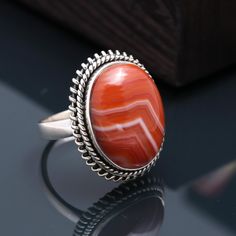 Stone : Red Banded Agate/ Botswana Agate Colour : Orange & White Weight : 7.61 Gram Size : US - 7 1/2, UK - O, EU - 55 Stone Dimension : 19.x14 MM Quality : AAAA  The most royal of agates, Botswana agate is famed for its history, scarcity and beauty. These stones are mostly found in the Bobonong district of Botswana and are famous for the extra fine banding of white, black, shades of grey and occasional touches of pink or salmon hues. The Gemsjewelleryshop offers the best quality products on the Handmade Carnelian Ring, Black Shades, Handmade Silver Ring, Botswana Agate, Colour Orange, Red Band, Banded Agate, Red Agate, Agate Ring