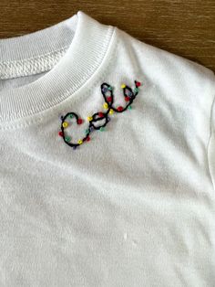 a white t - shirt with the word love embroidered on it