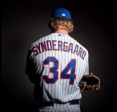 a professional baseball player poses for a photo in his uniform and mitt, with the number 34 on it's sleeve