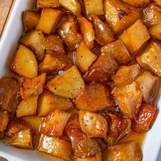 an apple and cinnamon baked dish in a white casserole dish on a wooden table