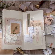 an open book sitting on top of a wooden table next to scissors and other items