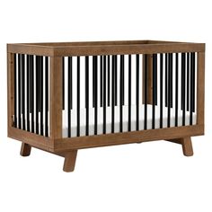 a wooden crib with white sheets and black stripes on the bottom, against a white background