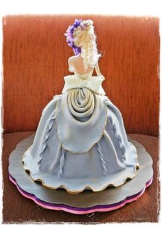 a cake shaped like a woman sitting on top of a table