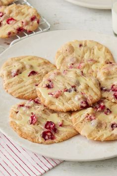 a plate full of cranberry white chocolate chip cookies on top of a table